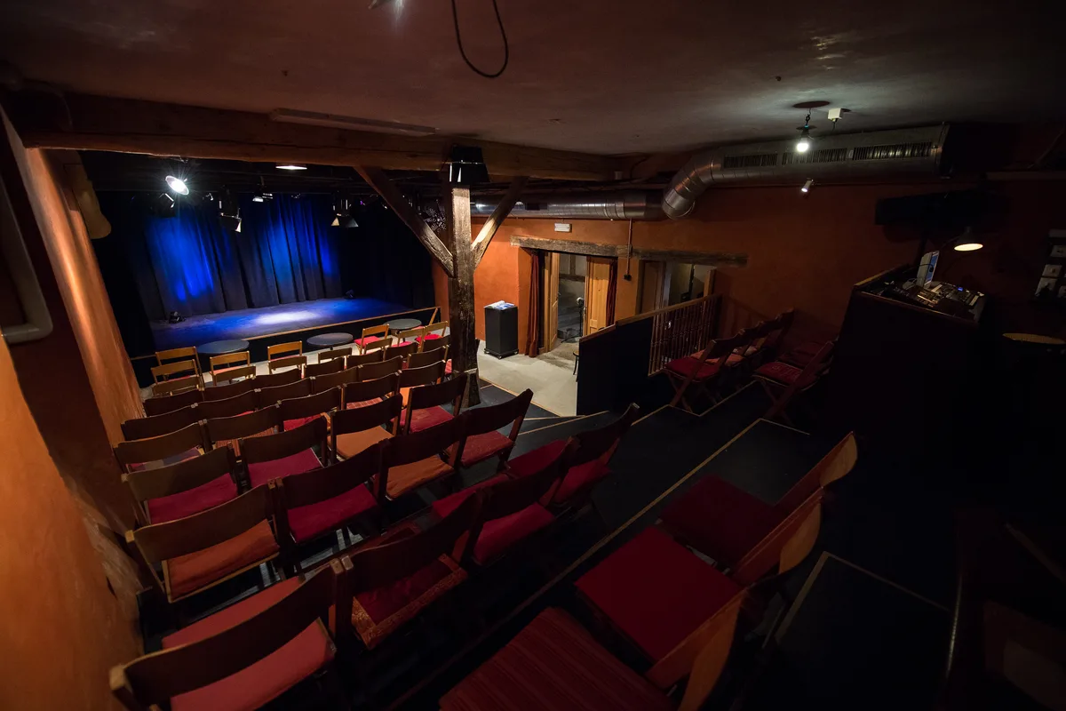 Ein kleiner Theaterraum mit einer Bühne.